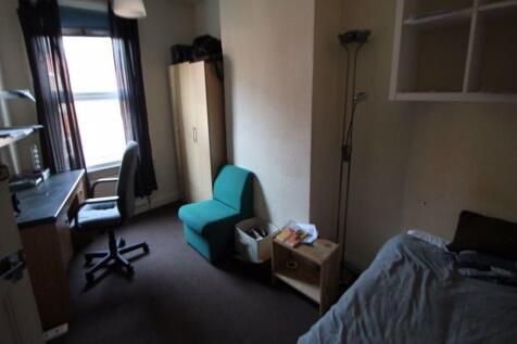 A cozy bedroom featuring a neatly made bed, a s...