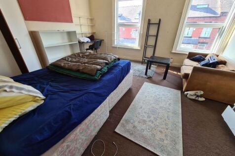 A bright, well-lit double bedroom with a cozy a...