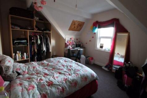 A spacious and cozy master bedroom featuring a ...