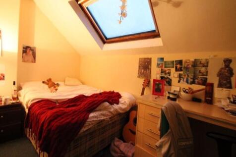 A cozy, well-lit bedroom featuring a skylight w...