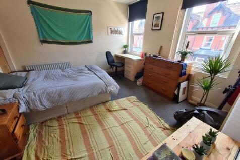 A bright and inviting bedroom featuring a comfo...