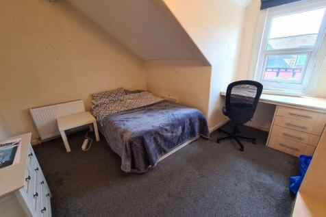 A cozy bedroom featuring a double bed, a desk a...