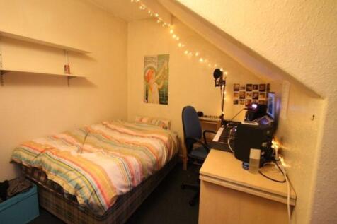 A cozy single bedroom featuring a neatly made b...