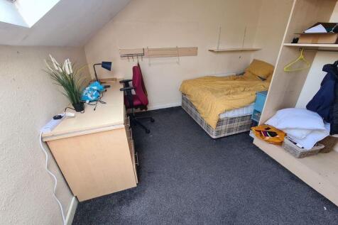 A cozy student bedroom featuring a single bed, ...