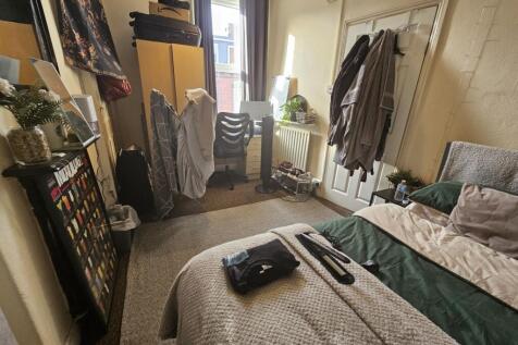 A cozy master bedroom featuring a comfortable d...