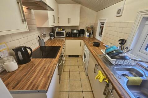 A tidy and modern kitchen featuring wooden coun...