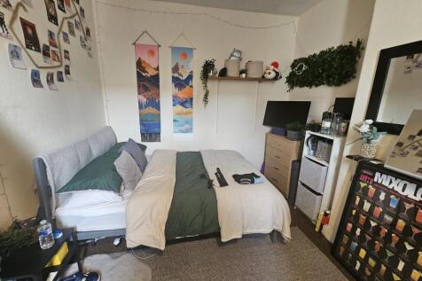 A cozy, well-organized single bedroom featuring...