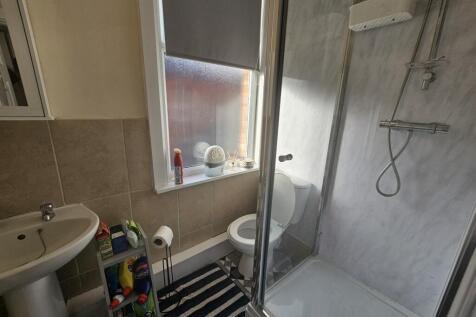 A clean, modern bathroom featuring a walk-in sh...