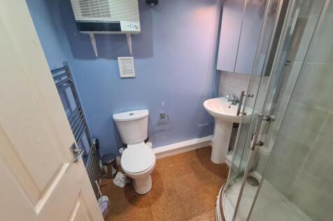 A well-maintained bathroom featuring a curved g...