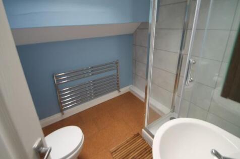 A modern bathroom featuring a glass-enclosed sh...