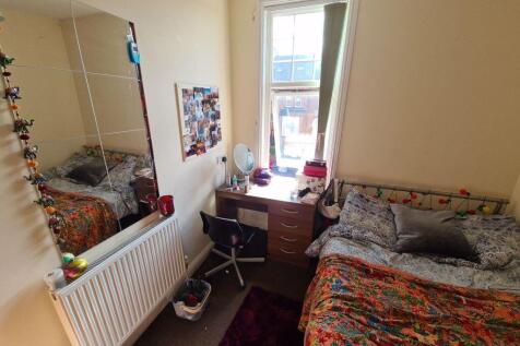 A cozy bedroom featuring a double bed with patt...