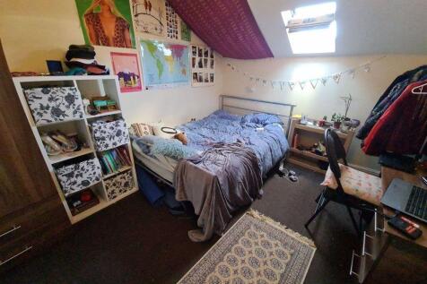 A cozy single bedroom featuring a comfortable b...