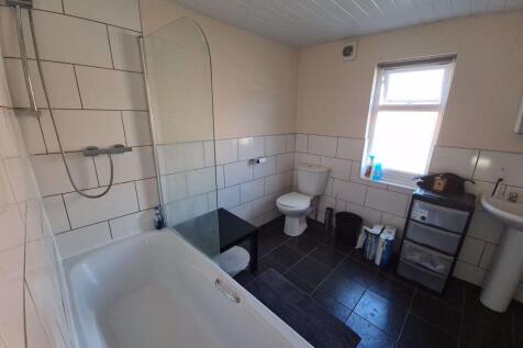 A spacious bathroom featuring a bathtub, large ...