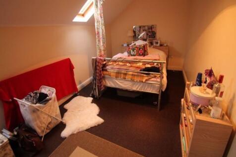 A cozy bedroom featuring a single bed with colo...