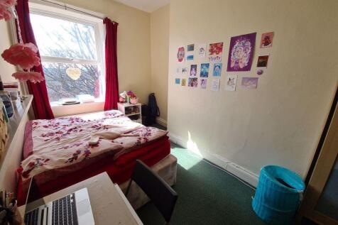 A cozy student bedroom featuring a double bed w...