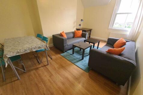 A spacious, well-lit living room with modern fu...