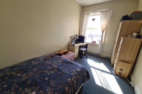 A cozy, well-lit double bedroom featuring a com...