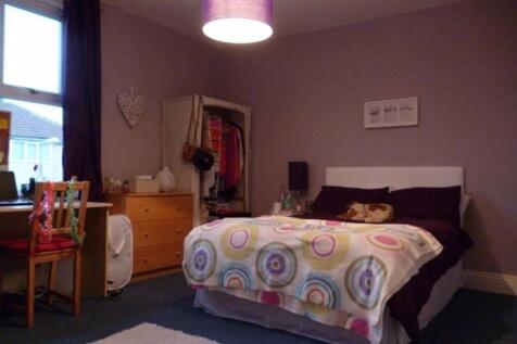 A well-maintained bedroom featuring a large bed...