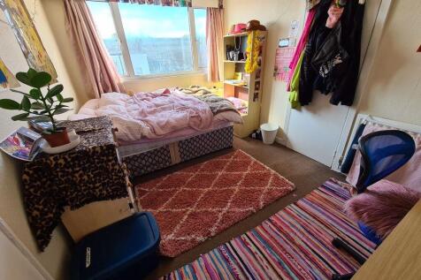 A bright and cozy master bedroom with a large w...