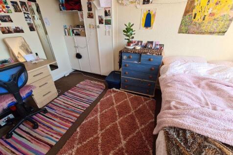 A cozy bedroom featuring a comfortable bed, a d...