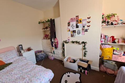 A cozy bedroom featuring a neatly made bed with...