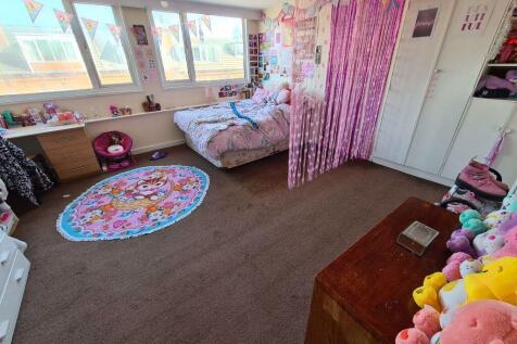 A cozy bedroom featuring a large bed with ample...