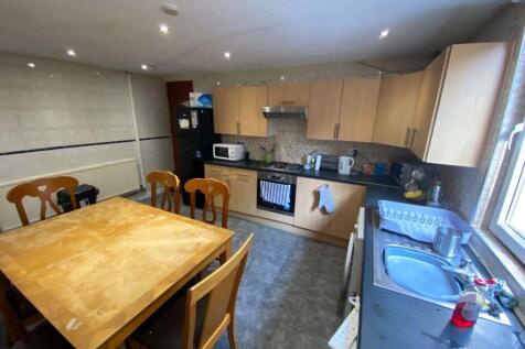 A modern kitchen featuring light wood cabinetry...