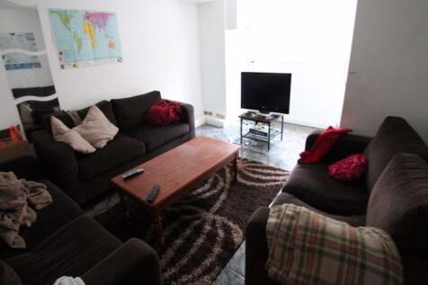 A cozy living room featuring comfortable dark s...