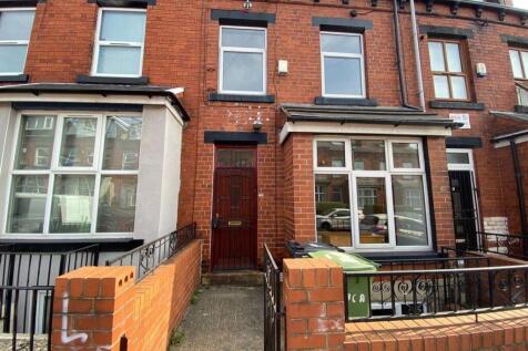 A charming red-brick terraced house featuring a...