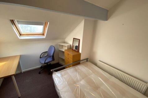 A cozy single bedroom featuring a comfortable b...