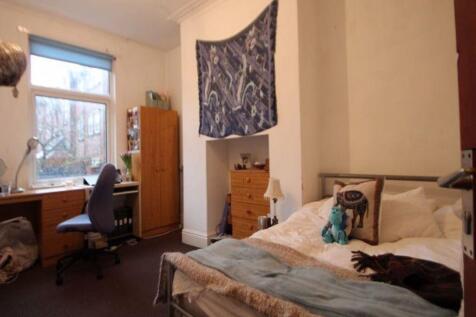 A cozy single bedroom featuring a comfortable b...