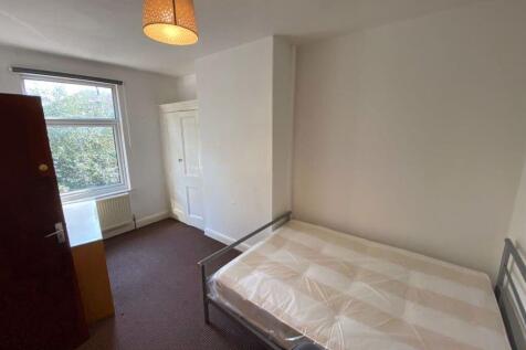 A simple, well-lit bedroom featuring a single b...