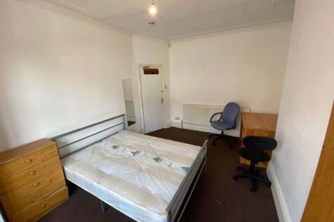 A tidy single bedroom featuring a metal bed fra...