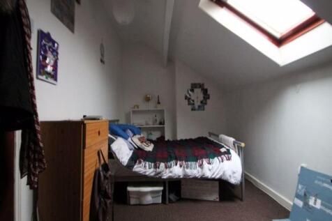 A cozy single bedroom featuring a skylight wind...