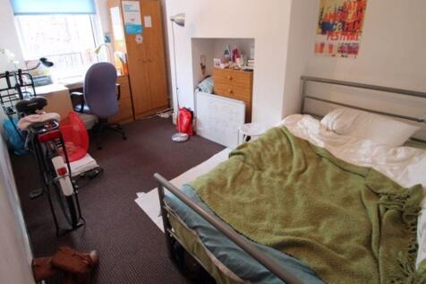 A cozy single bedroom featuring a comfortable b...