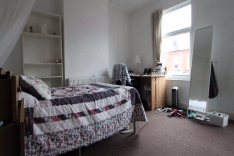 A cozy single bedroom featuring a comfortable b...