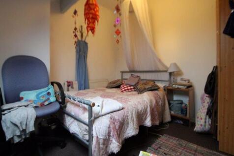 Cozy single bedroom featuring a comfortable bed...