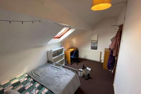 Cozy single bedroom featuring a skylight window...
