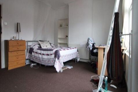 A simple and cozy single bedroom featuring a ti...