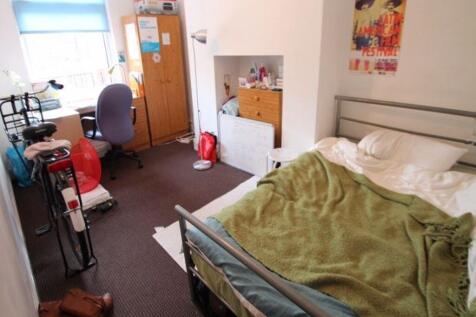 A cozy single bedroom featuring a comfortable b...