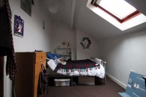 A cozy single bedroom featuring a skylight wind...