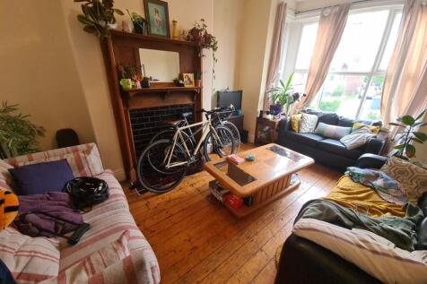 A welcoming and spacious living room filled wit...