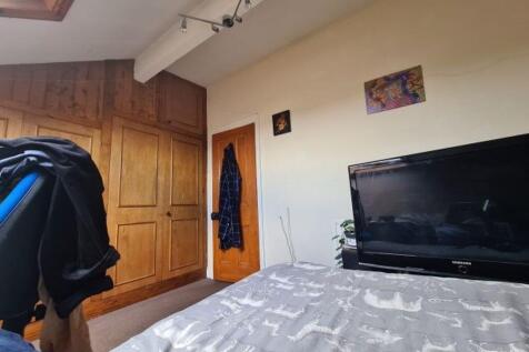 A cozy bedroom featuring a comfortable bed, a T...