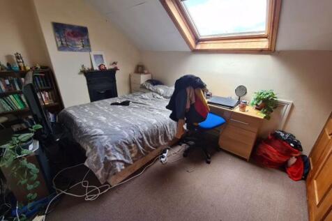 A cozy single bedroom with a comfortable bed, a...