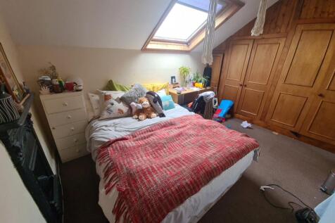 A cozy master bedroom with a comfortable bed, a...