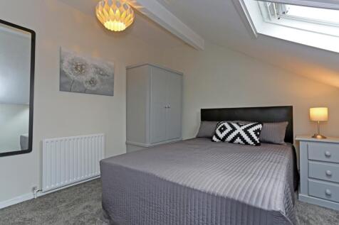 Bright and cozy master bedroom featuring a comf...