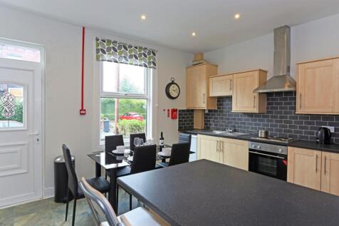 A modern kitchen with light wooden cabinets, a ...