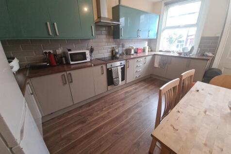 A bright and modern kitchen featuring wood-effe...