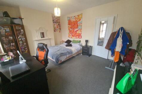 A cozy single bedroom featuring a neatly made s...