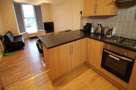 A modern kitchen area with wooden flooring and ...